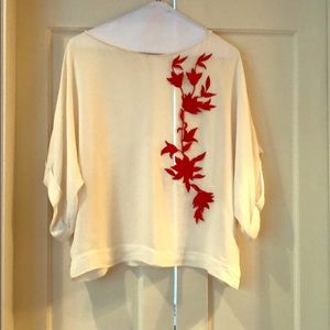 White blouse with red floral appliqué